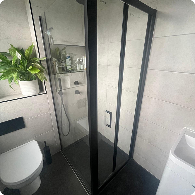 Walk-in shower with black framed glass screen